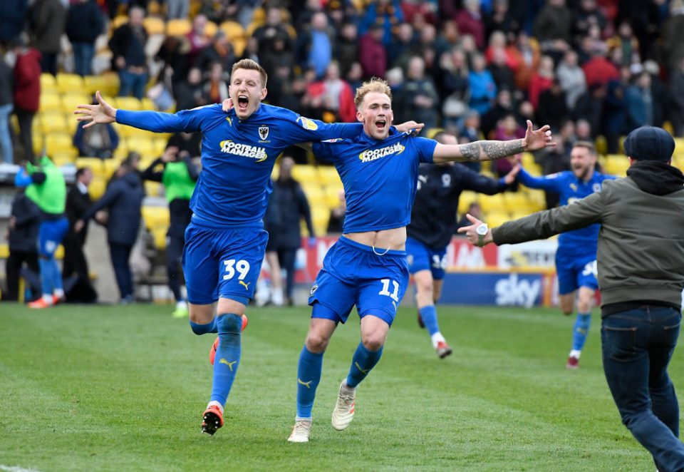 BRADFORD, ENGLAND - MAY 04: Joe Piggott and Mitchell Pinnock of AFC Wimbledon celebrate with fans after the 0-0 with Bradford results in AFC Wimbledon staying up in League One following the Sky Bet League One match between Bradford City and AFC Wimbledon at Northern Commercials Stadium on May 04, 2019 in Bradford, United Kingdom. (Photo by George Wood/Getty Images)