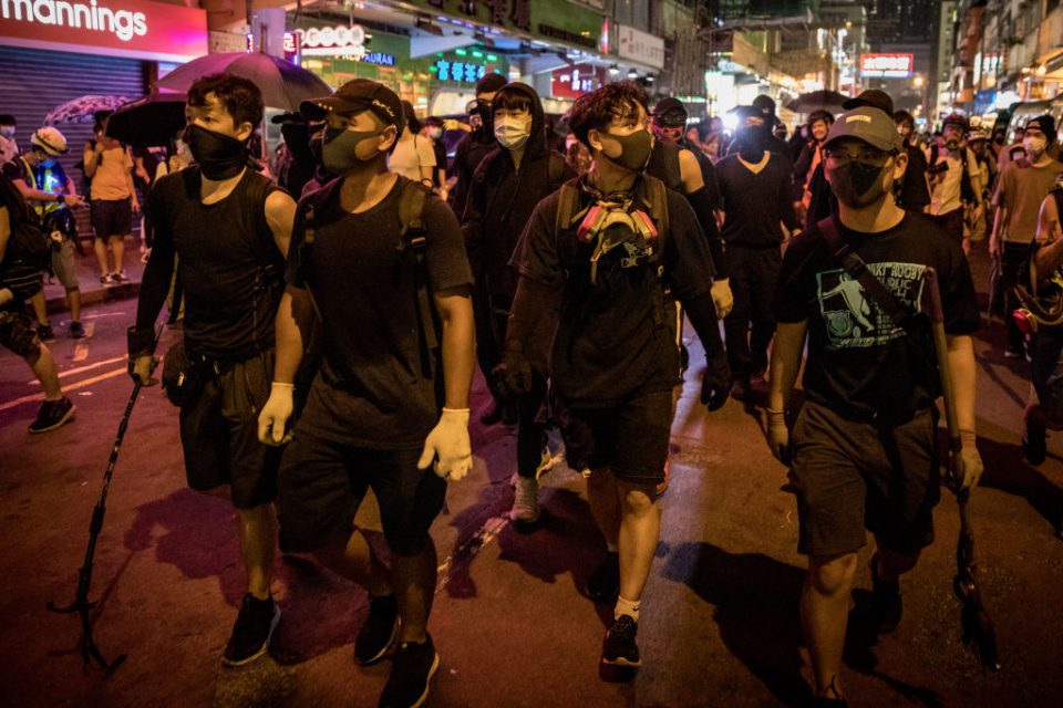 Hong Kong protesters walk down a city street in a pro-democracy demonstration