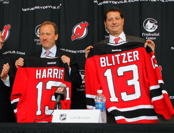 NEWARK, NJ - AUGUST 15:  Co-owners of the New Jersey Devils Joshua Harris (L) and David Blitzer pose for a photo with their jerseys during the press conference announcing the new ownership of the New Jersey Devils on August 15, 2013 in Newark, New Jersey.  (Photo by Andy Marlin/Getty Images)